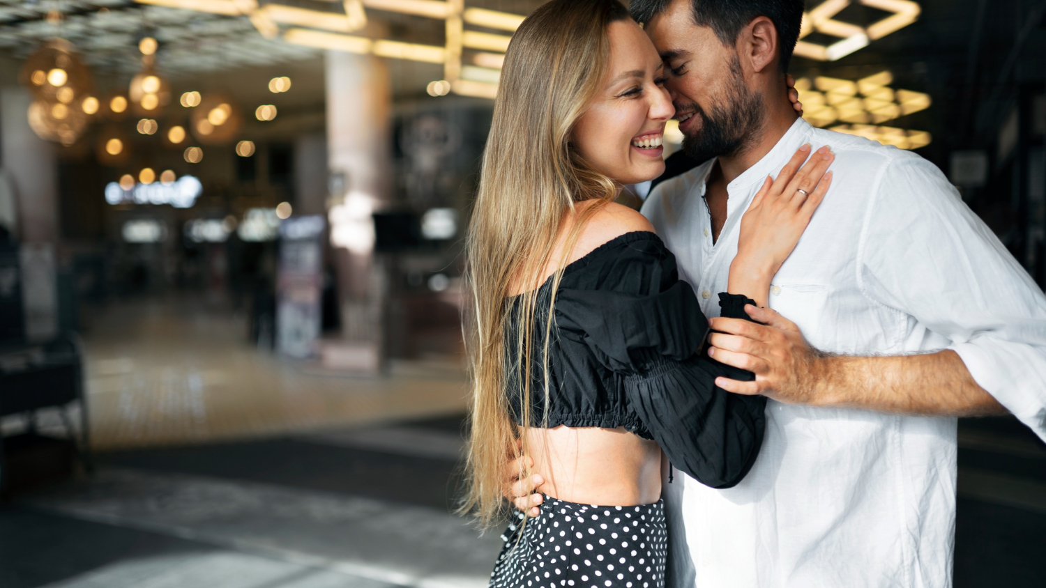 Pareja bailando bachata con movimientos sensuales y cercanos, conectando al ritmo de la guitarra