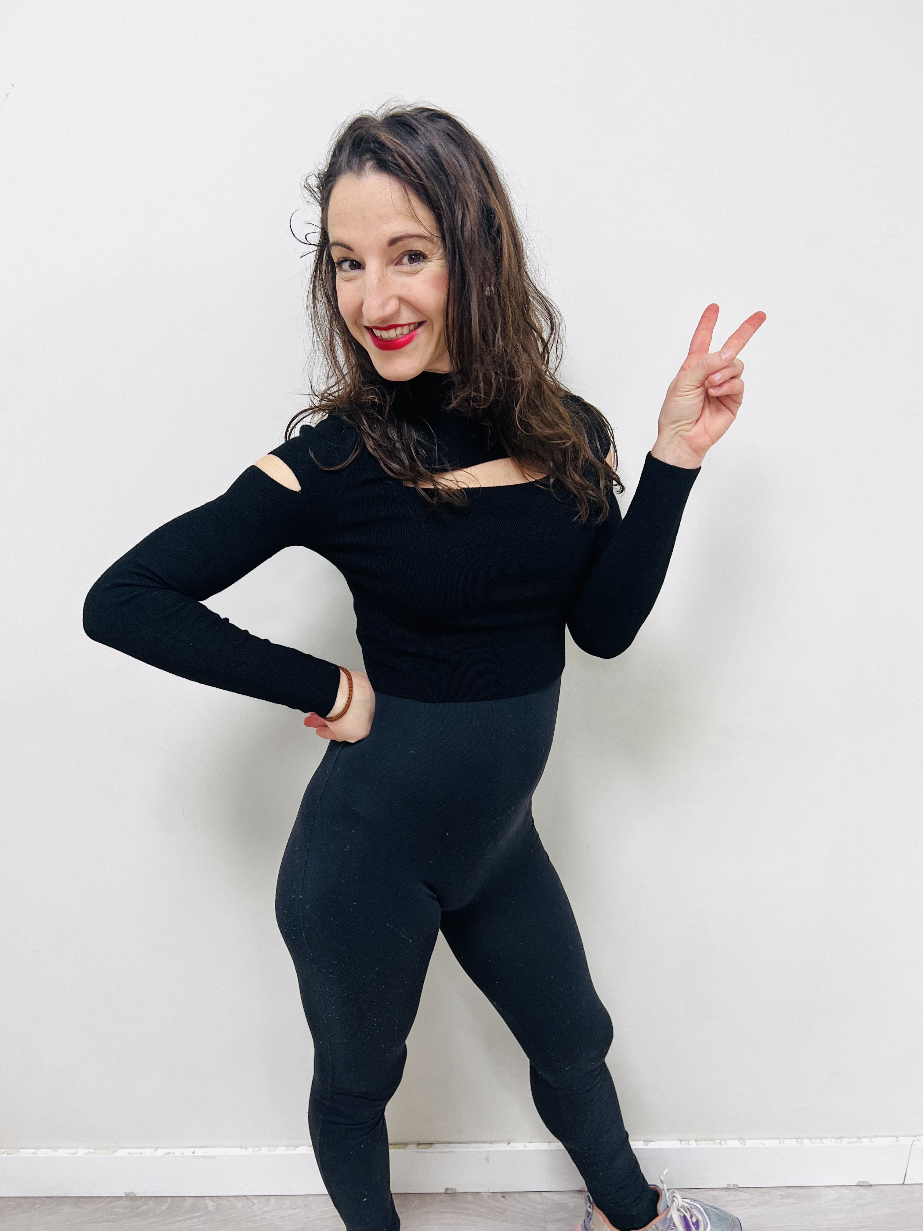 Naiara sonriendo, profesora de salsa cubana con atuendo de baile, mostrando pasión por la enseñanza