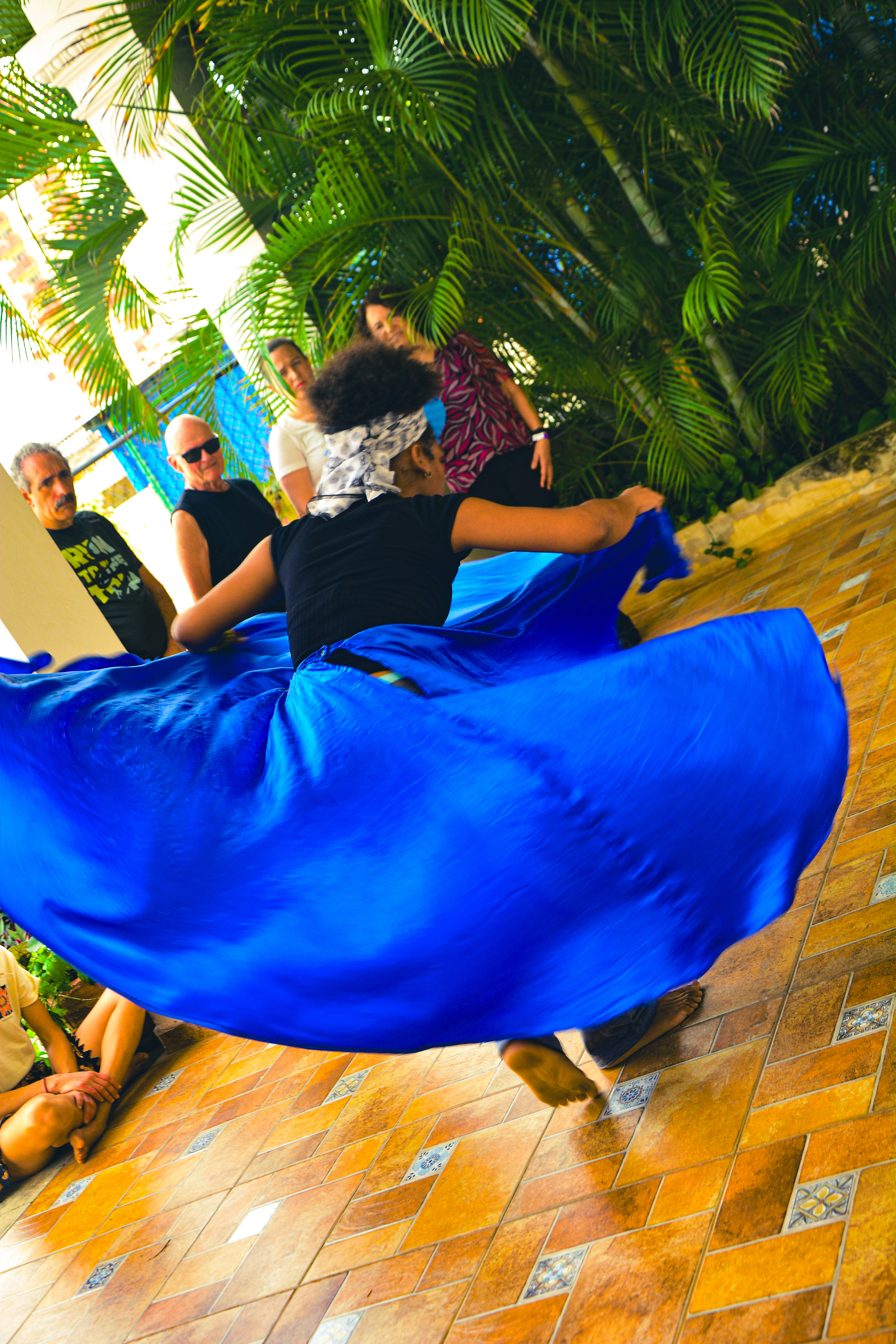 Bailarina ejecutando movimientos de ritmos afrocubanos con expresión corporal intensa y conexión con tambores